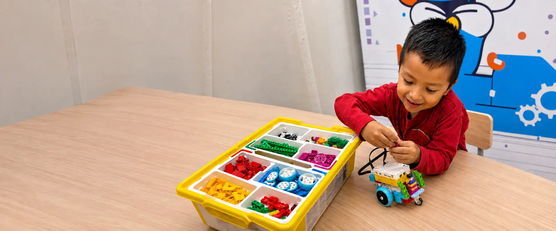 El mismo niño armando un robot completo con piezas en el aula de MusUQ Lab