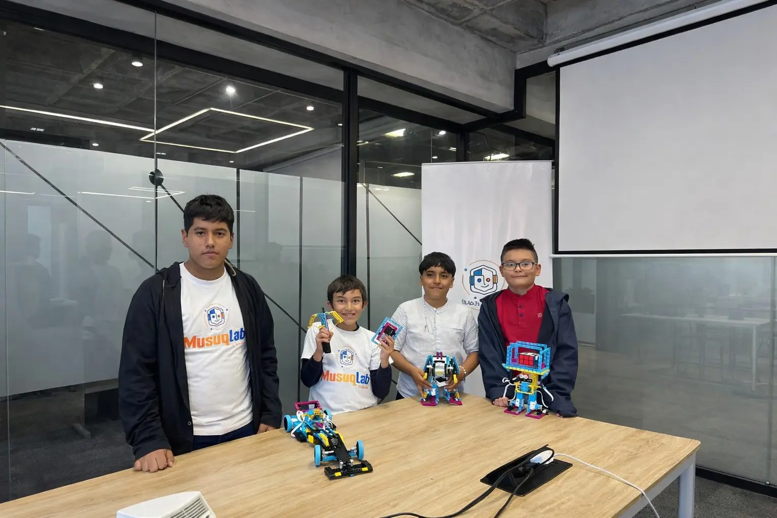 Mentor de MusUQ Lab acompañando a un grupo de niños con sus robots en clase